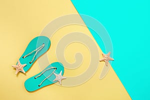 Flat lay of composed miniature of beach lounge area with summer shoes - flip-flops and small sea stars