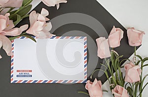 Flat lay composition with air mail envelope and flowers.