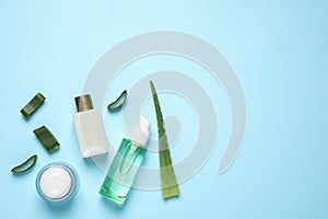 Flat lay composition with aloe vera and cosmetics on light blue background. Space for text