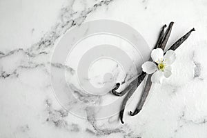 Flat lay composition with aromatic vanilla sticks and flower on marble background