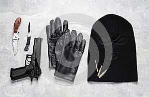 Flat lay composition with balaclava and weapons on light table