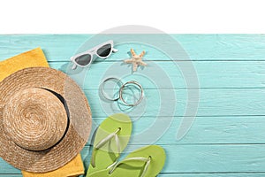 Flat lay composition with beach accessories on wooden background.