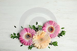 Flat lay composition with beautiful bright gerbera flowers on wooden background, top view.
