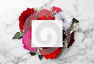 Flat lay composition with beautiful dahlia flowers and blank card on white marble background, flat lay. Space for text