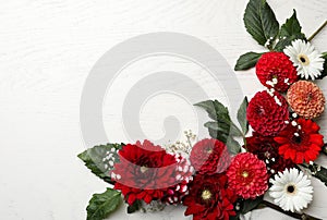 Flat lay composition with beautiful dahlia flowers on white wooden background. Space for text