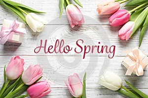 Flat lay composition of beautiful flowers and text Hello Spring