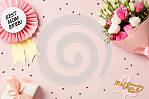 Flat lay composition with best mom ever rosette, bouquet of flowers, gift box