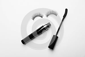 Flat lay composition of black mascara and false eyelashes