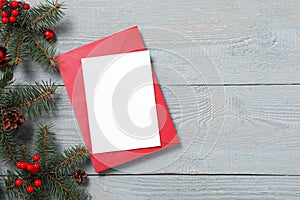 Flat lay composition with blank greeting card and Christmas decor on grey wooden table, space for text