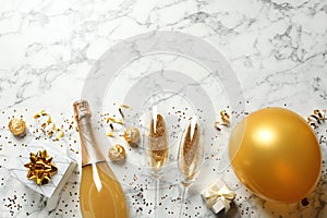 Flat lay composition with bottle of champagne for celebration on white marble background