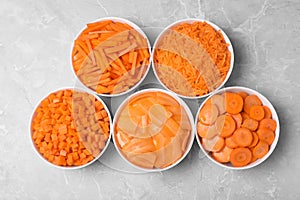 Flat lay composition with bowls of differently cut carrots