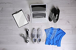 Flat lay composition of business items with sport accessories on white wooden background. Life and work balance concept