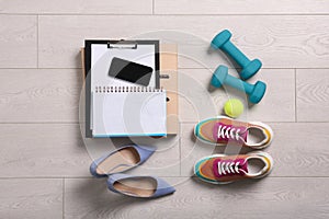 Flat lay composition with business supplies and sport equipment on white wooden floor. Concept of balance between work and life