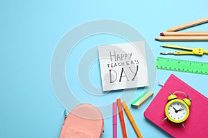 Flat lay composition of card with inscription HAPPY TEACHER`S DAY and stationery on light blue background