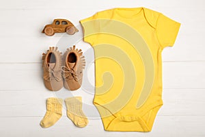 Flat lay composition with child`s clothes and booties on white table