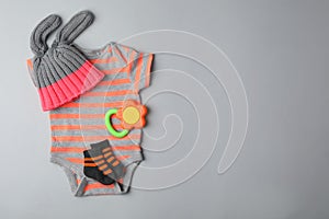 Flat lay composition with child`s clothes and teether on background, space for text