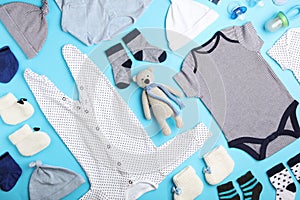 Flat lay composition with child`s clothes and toy bear on blue background
