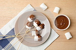 Flat lay composition with chocolate fondue in bowl and marshmallows