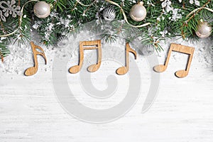 Flat lay composition with Christmas decor and music notes on white wooden table