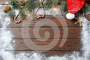 Flat lay composition with Christmas decor, snow and space for text on wooden background.