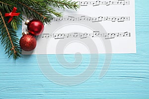 Flat lay composition with Christmas decorations and music sheet on blue wooden table