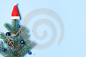 Flat lay composition with Christmas tree branch, Santa hat, wooden music notes on color background