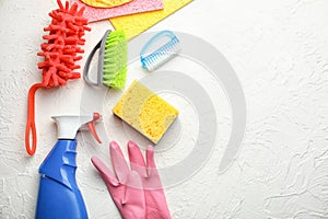 Flat lay composition with cleaning supplies on white textured background