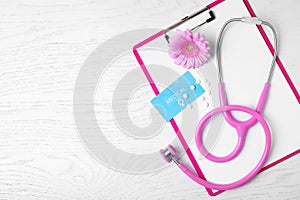 Flat lay composition with clipboard and stethoscope on white wooden background. Gynecology concept