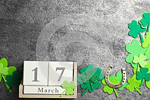 Flat lay composition with clover leaves and block calendar on grey stone background. St. Patrick`s day