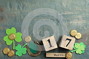 Flat lay composition with clover leaves and calendar on blue wooden background, space for text. St. Patrick`s day