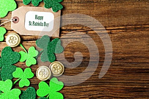 Flat lay composition with clover leaves and gold coins on table, space for text. St. Patrick`s Day celebration