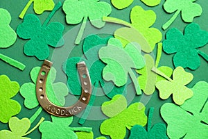 Flat lay composition with clover leaves and horseshoe on background. St. Patrick`s day