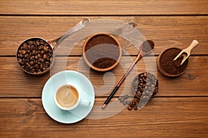 Flat lay composition with coffee grounds and roasted beans on wooden table