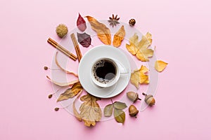 Flat lay composition with colorful Autumn cup of coffee and leaves on a color background. top view