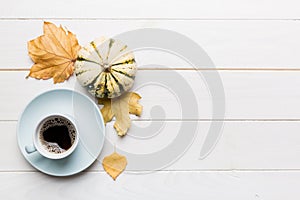 Flat lay composition with colorful Autumn cup of coffee and leaves on a color background. top view