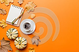 Flat lay composition with colorful Autumn cup of coffee and leaves on a color background. top view