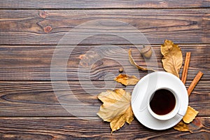 Flat lay composition with colorful Autumn cup of coffee and leaves on a color background. top view