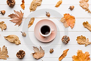 Flat lay composition with colorful Autumn cup of coffee and leaves on a color background. top view