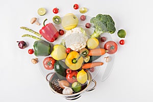 Flat lay composition of colorful vegetables and fruits in colander isolated on white background