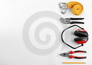 Flat lay composition with construction tools and safety equipment on white background
