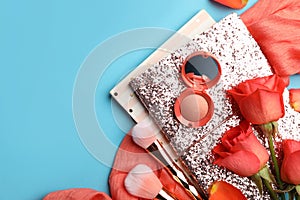 Flat lay composition with coral cosmetics and flowers on light blue background