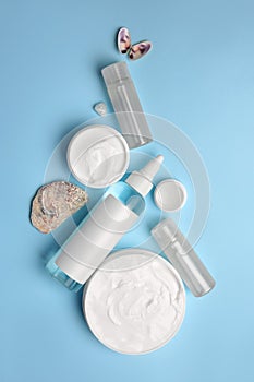 Flat lay composition with cosmetic products on light blue background