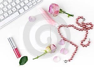 Flat lay composition with cosmetics and pink rose flowers. Top view