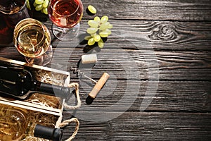 Flat lay composition with crates and bottles of wine on wooden table