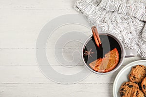 Flat lay composition with cup of hot mulled wine on white wooden table. Winter drink