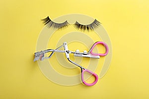 Flat lay composition of curler and false eyelashes