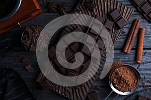 Flat lay composition with dark chocolate on wooden table