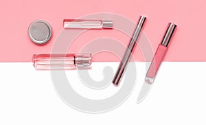 Flat lay composition with decorative makeup products and parfume on coral and isolated white background. Makeup and