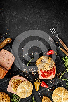 Flat lay composition of delicious hot dogs and sandwiches with different toppings on the dark background