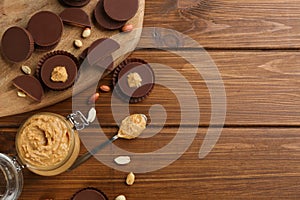 Flat lay composition with peanut butter cups on wooden table, space for text photo